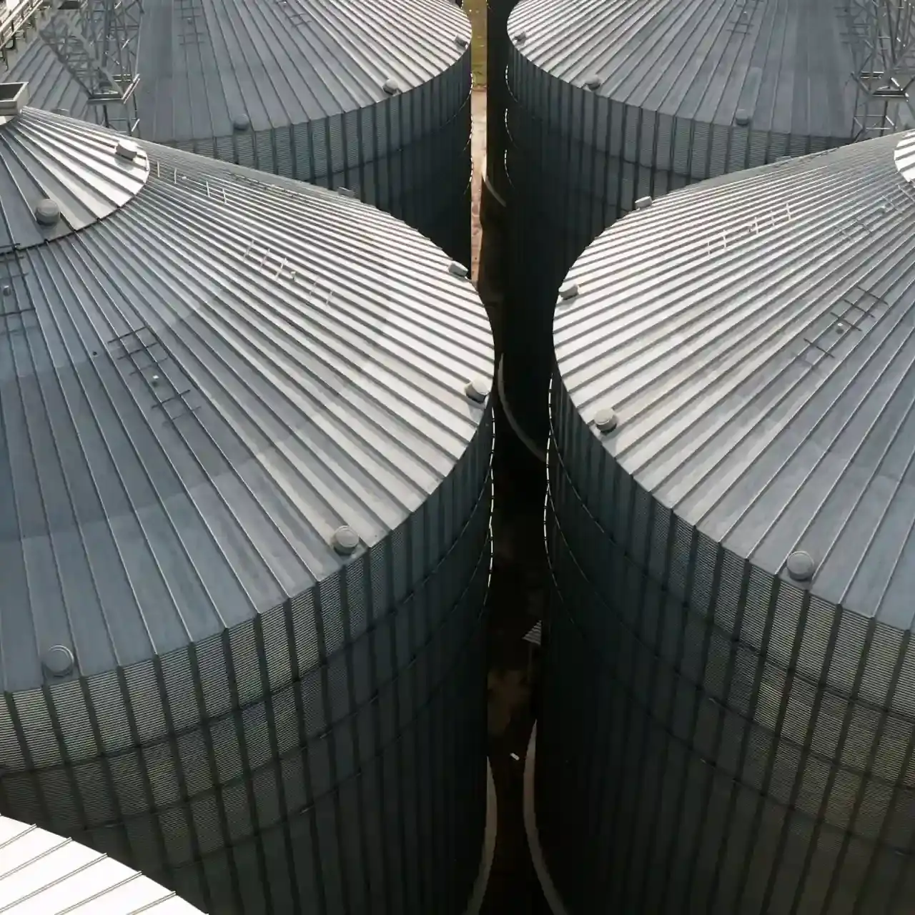 Detalhe da infraestrutura de armazenamento de soja. A vista superior dos silos metálicos representa a fase de estocagem, onde o controle de temperatura e ventilação é vital para manter a qualidade do grão colhido.