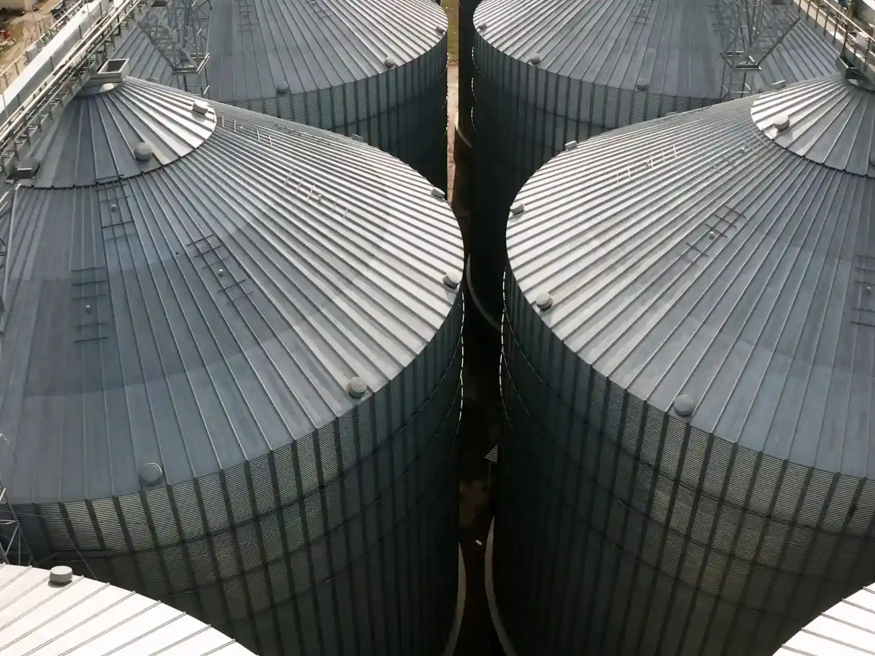 Detalhe da infraestrutura de armazenamento de soja. A vista superior dos silos metálicos representa a fase de estocagem, onde o controle de temperatura e ventilação é vital para manter a qualidade do grão colhido.