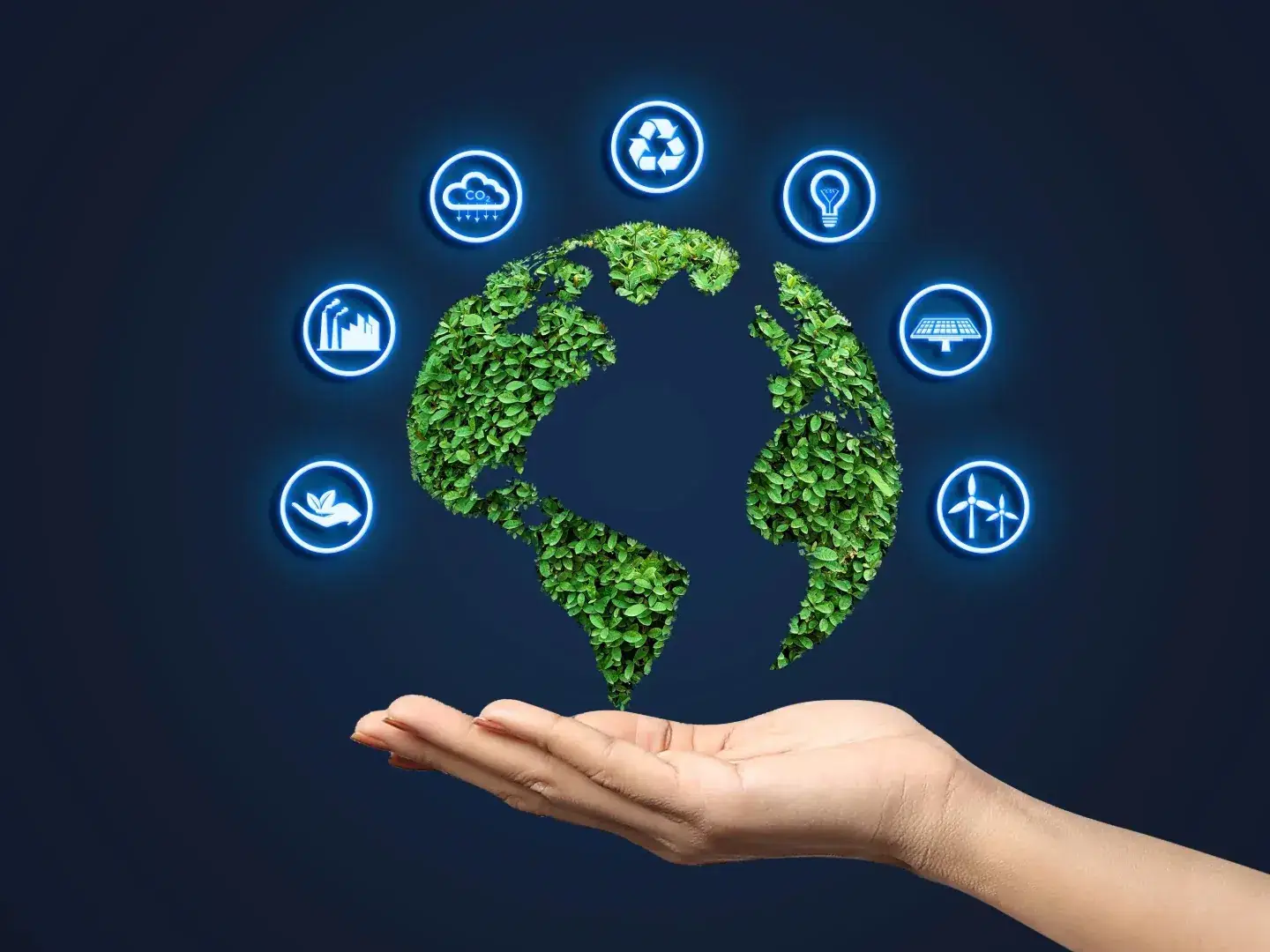 Imagem ilustrativa de uma mão segurando o planeta Terra. Os continentes estão cobertos de plantas e ao redor do planeta estão inclusos diferentes símbolos, que representam um modelo de produção sustentável.