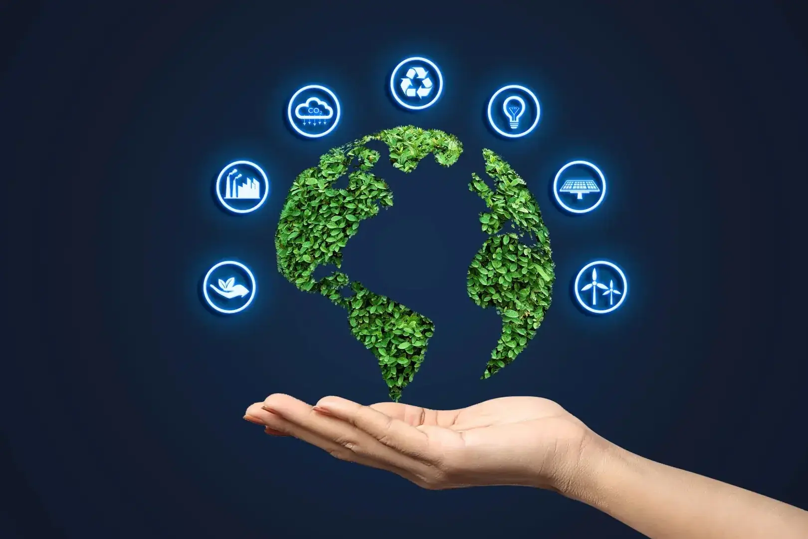 Imagem ilustrativa de uma mão segurando o planeta Terra. Os continentes estão cobertos de plantas e ao redor do planeta estão inclusos diferentes símbolos, que representam um modelo de produção sustentável.